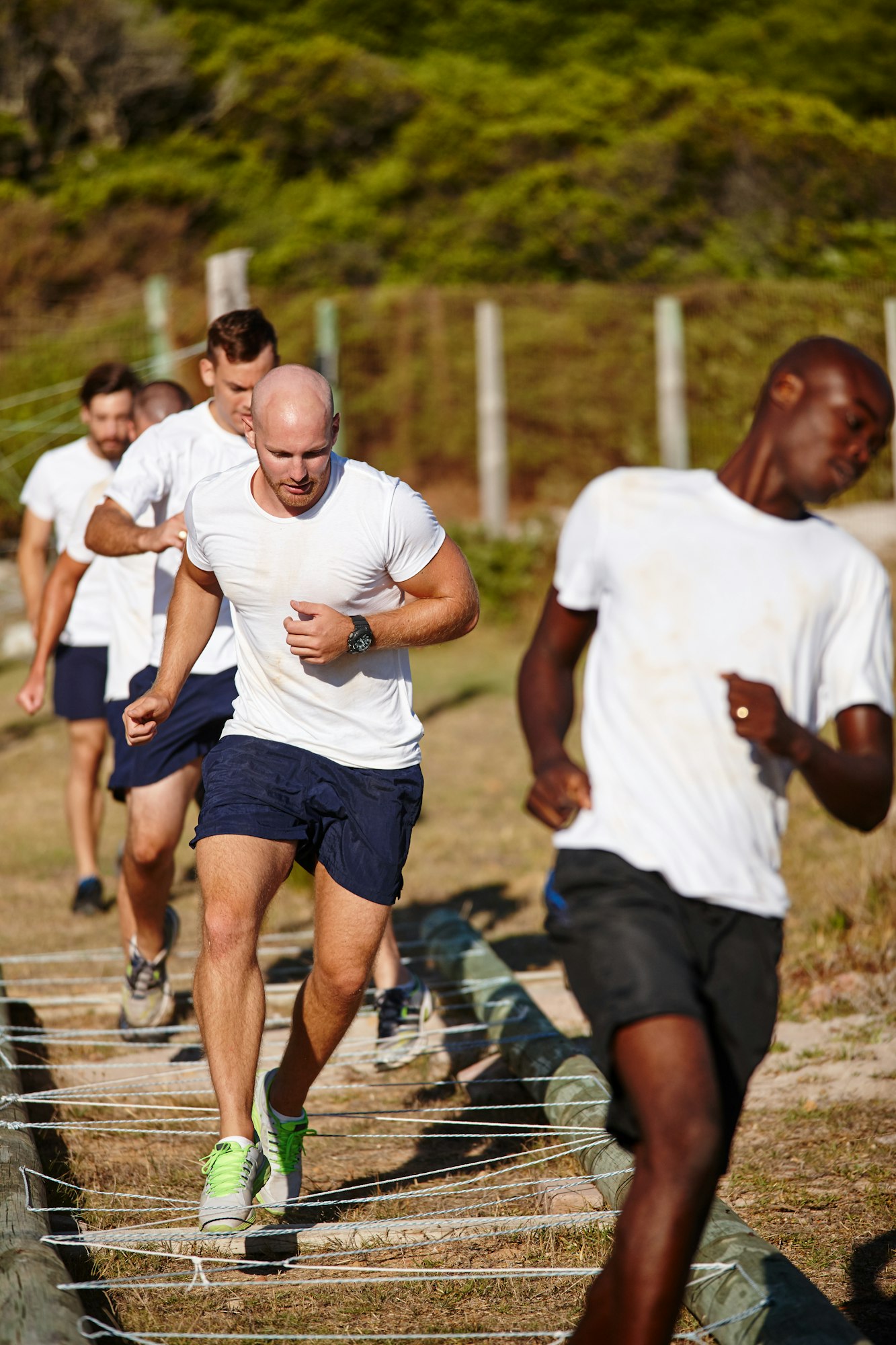 Harder, better, faster, stronger. Shot of a group of men doing drills at a military bootcamp.