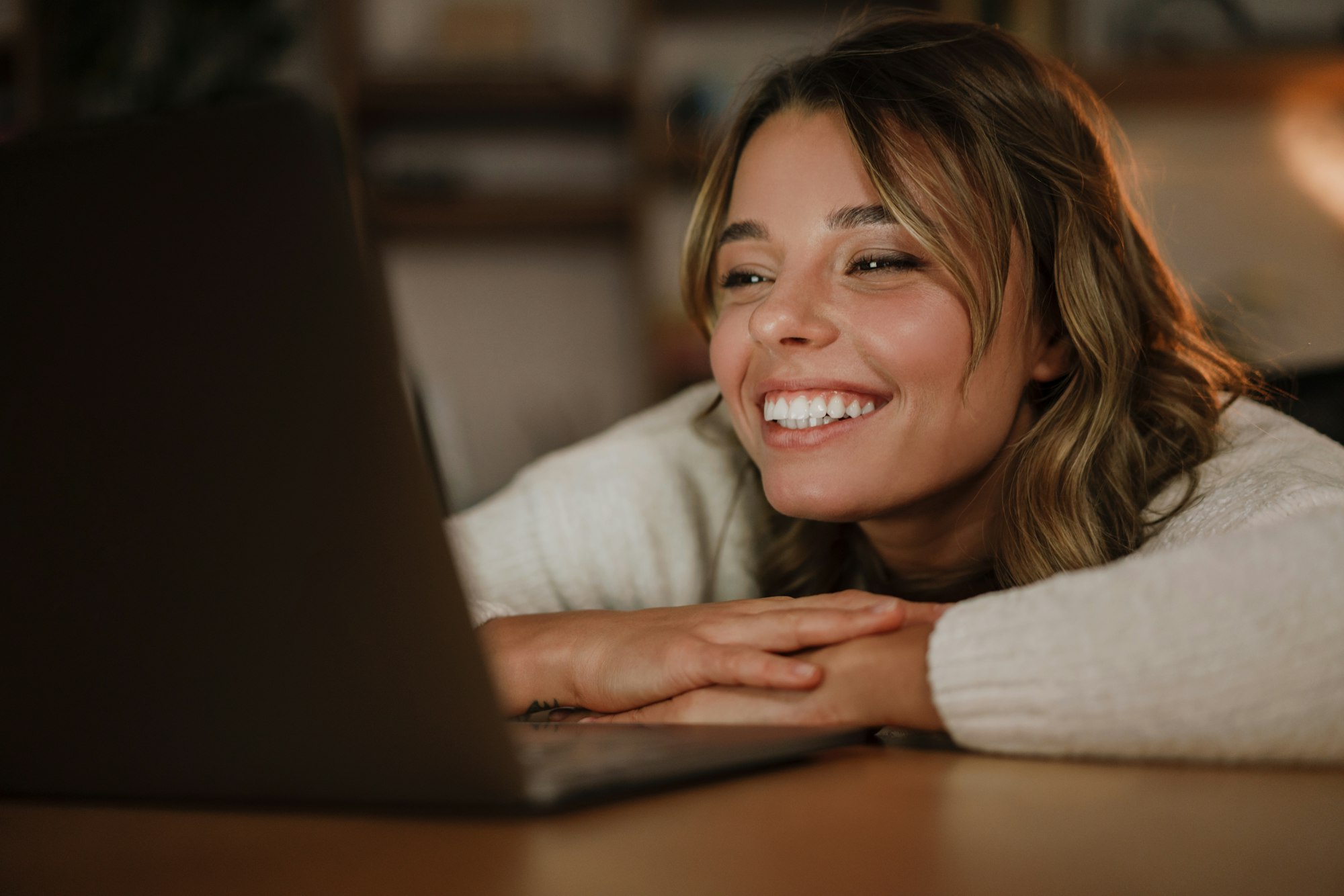 Smiling young woman in earphones watching webinar